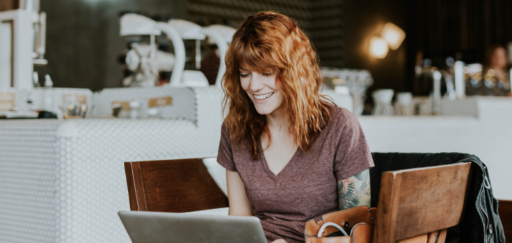 Woman reading a laptop in a cafe